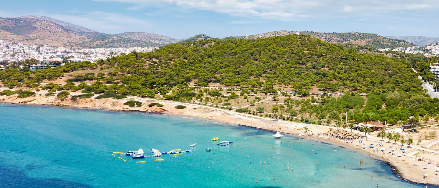 Aerial view of a beach on an overgrown coastline with turquoise water.