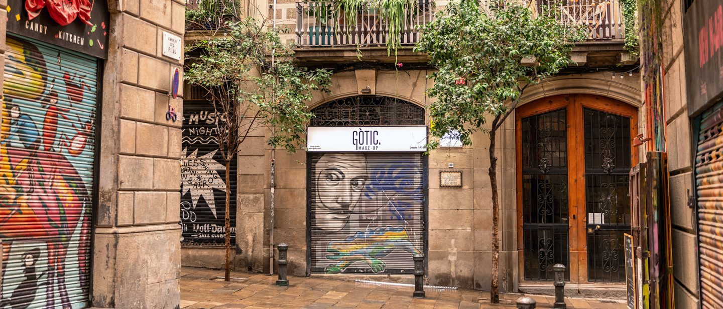 Shops in the Gothic Quarter with graffiti-covered doors and a historic charm
