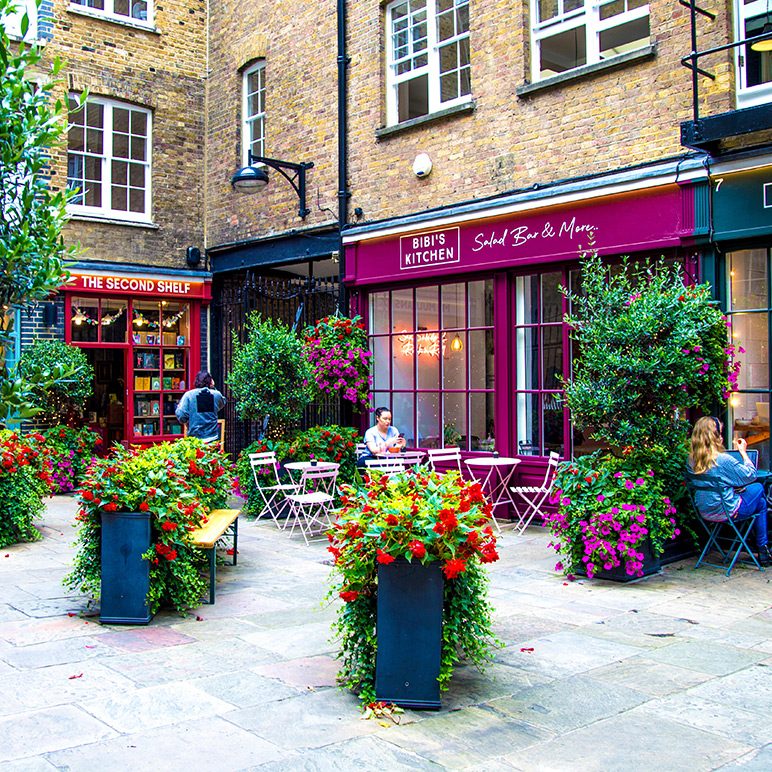 Backyard in Soho with colorful flowerpots and pink-painted store