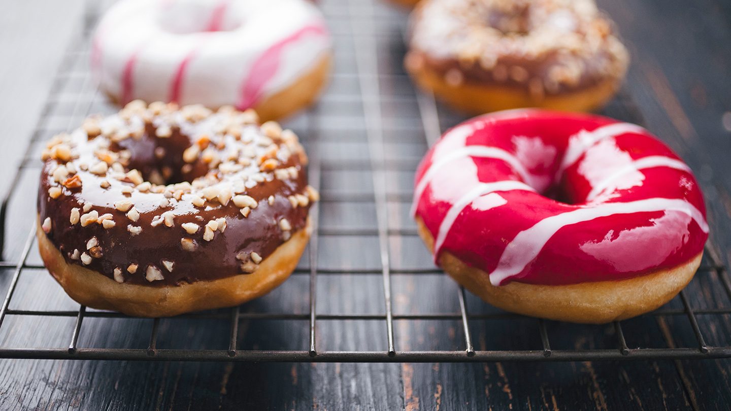 Colourful donuts on a baking rack