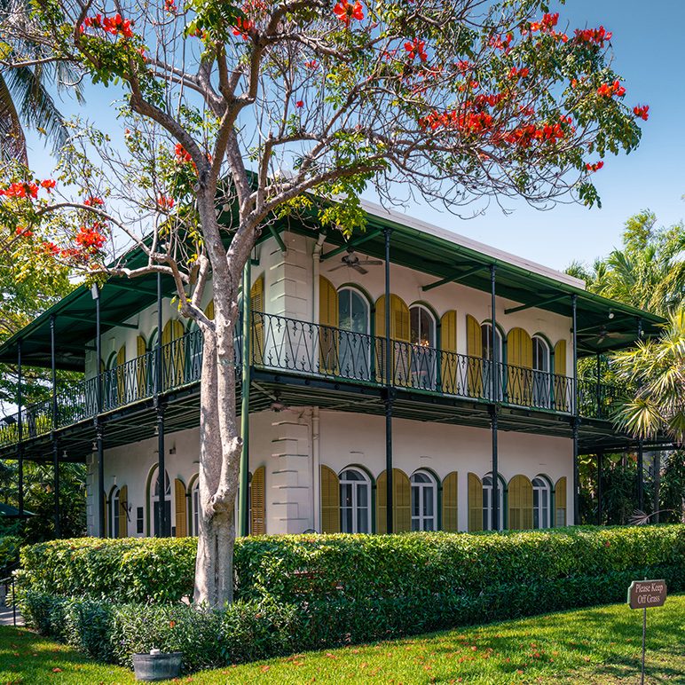 The former home of the writer Ernest Hemingway in Key West. In front of it is a tree with red blossoms