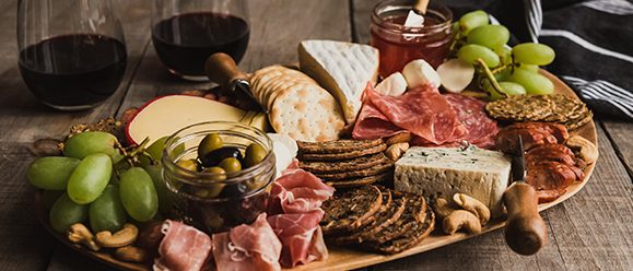 Appetiser platter with sausage, cheese, grapes and bread