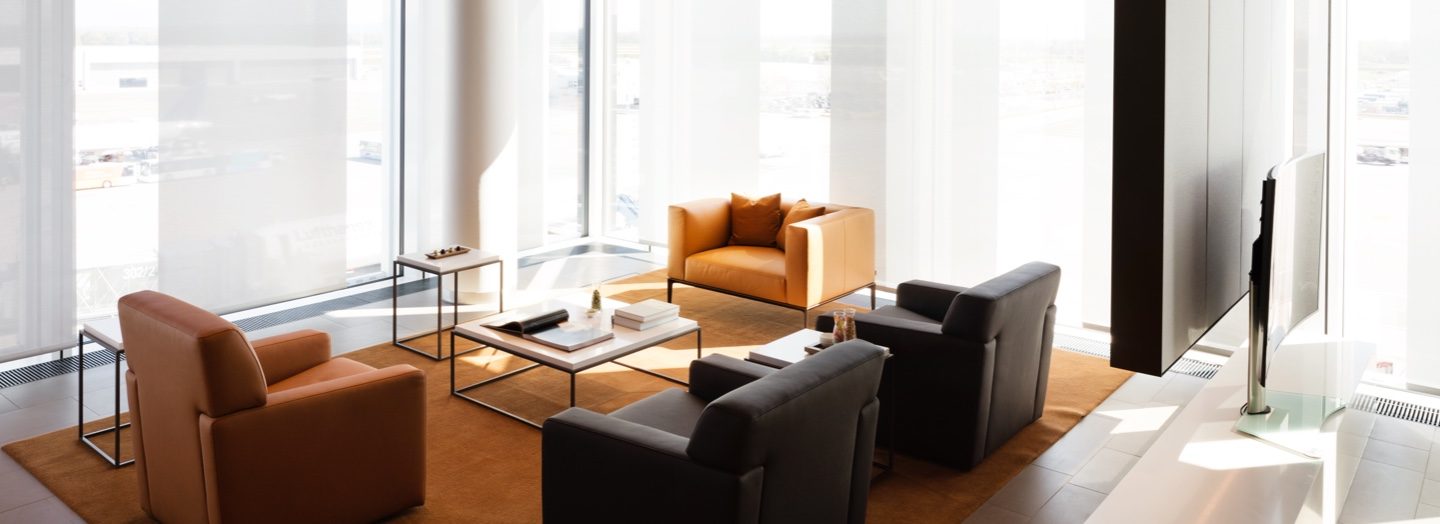 Premium airport lounge seating area with a clear view of the airfield tarmac.
