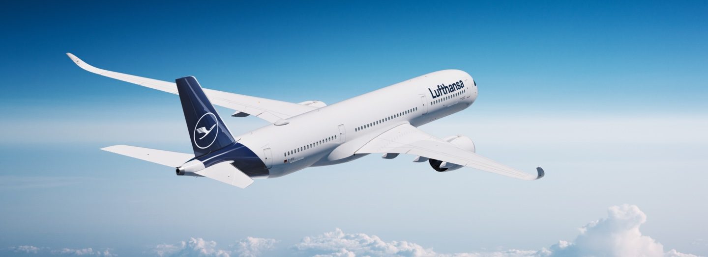 Lufthansa airplane flying above clouds in a blue sky.
