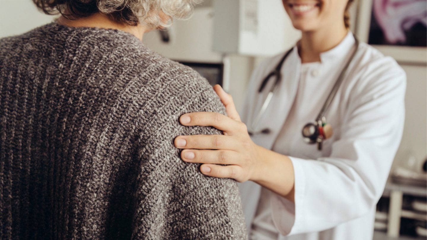 Medical professional comforting an older person.