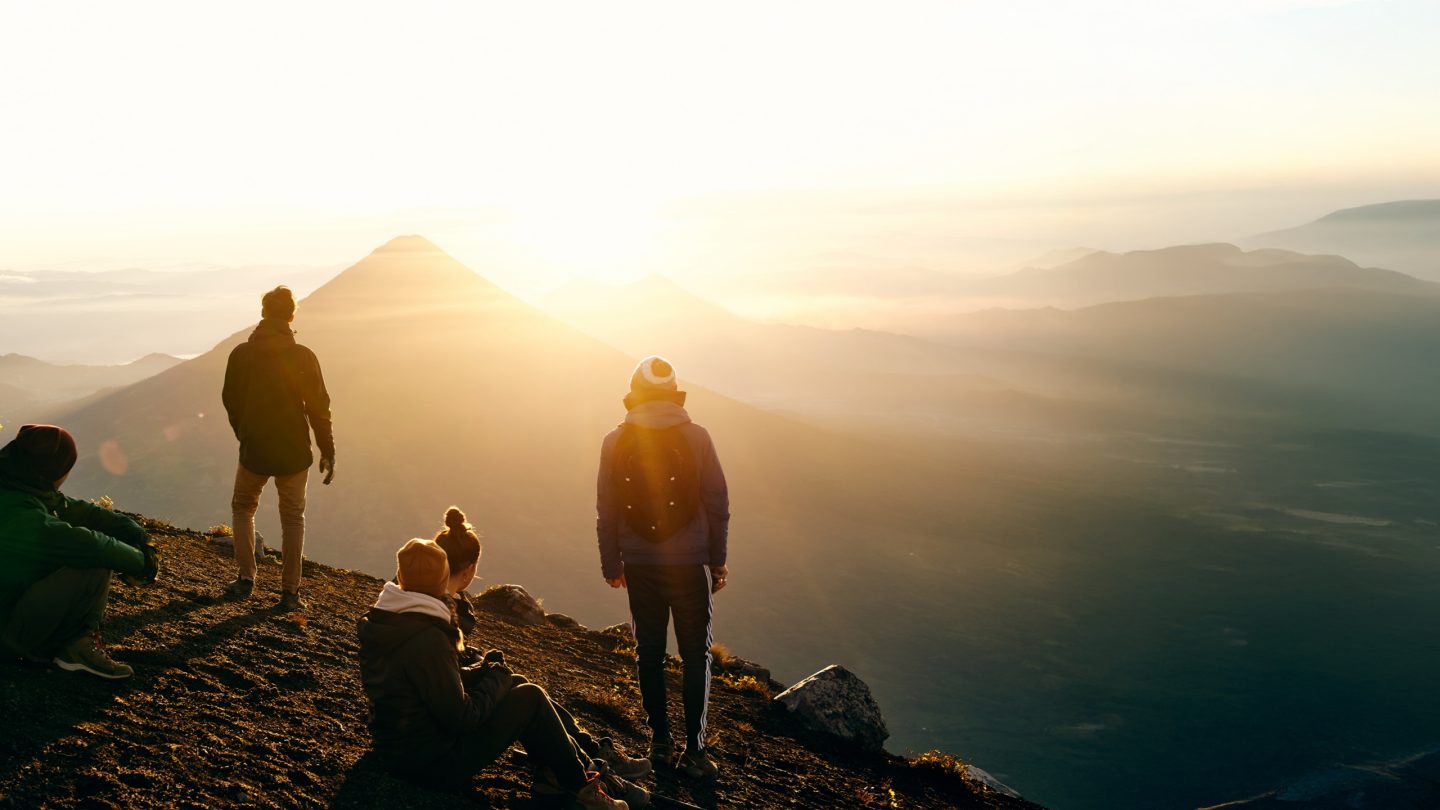 People looking at a mountain view at sunrise.