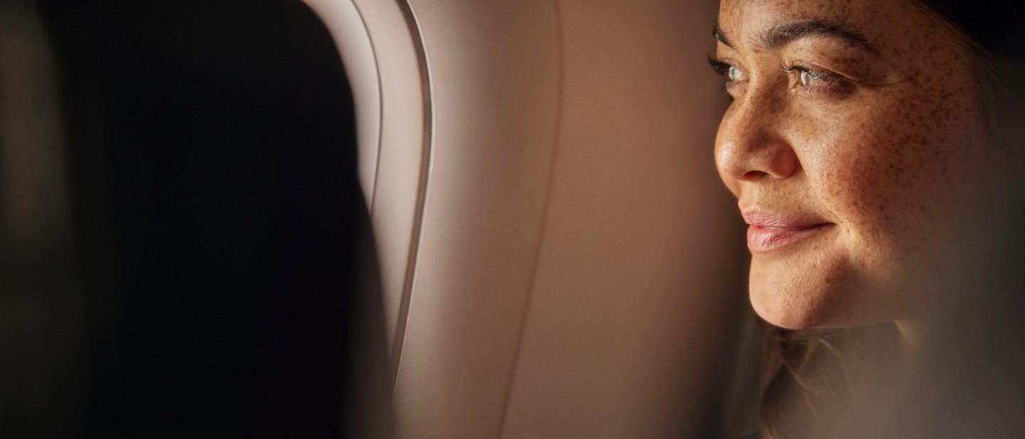 The sun’s rays warm the face of a smiling female passenger.