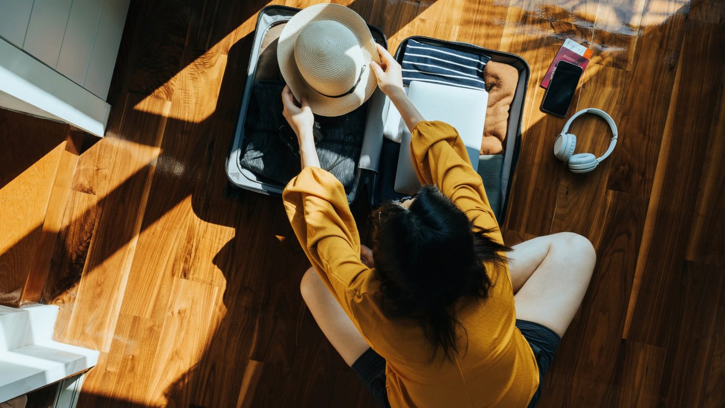 Overhead view of a woman packing a suitcase.