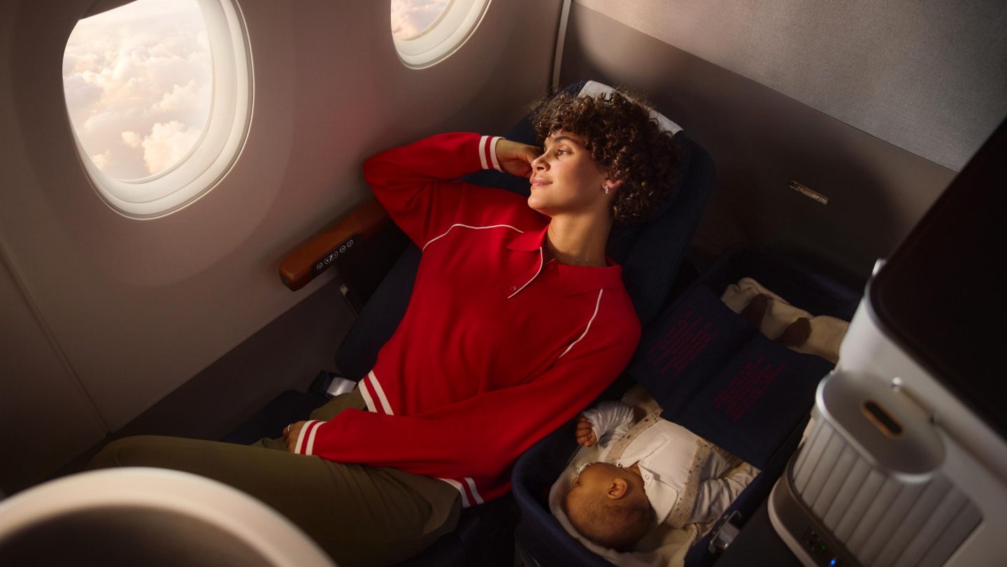 Woman and baby resting in a business class seat.