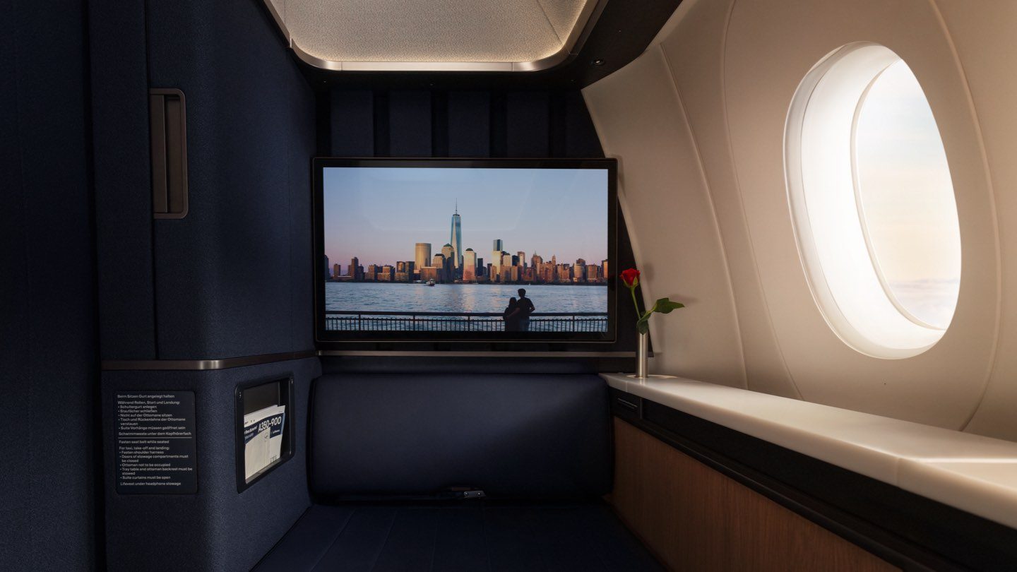Experience luxury in a private airline suite with a screen displaying NYC, a rose, and a window.