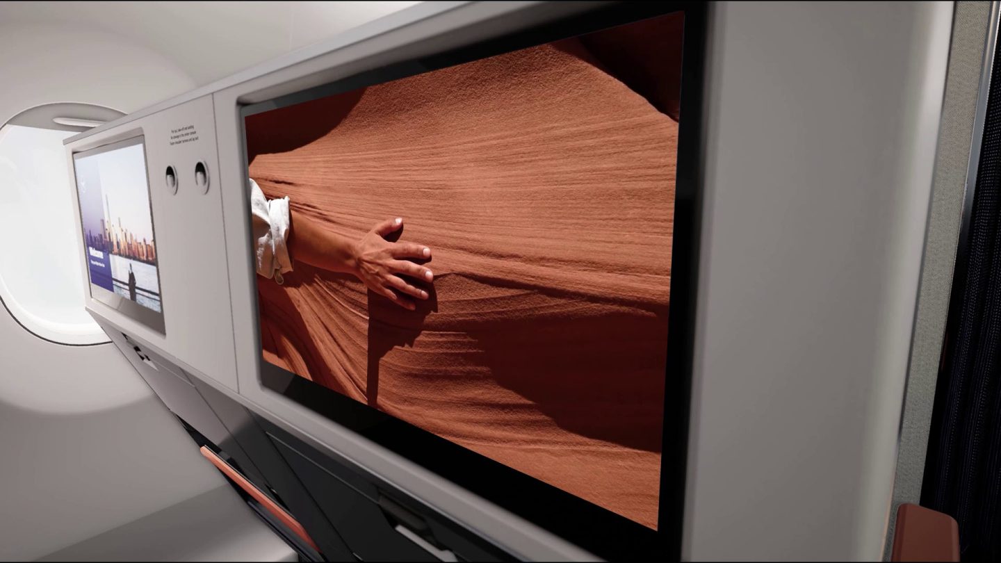 Modern airplane cabin with dual screens displaying travel destinations and immersive content.