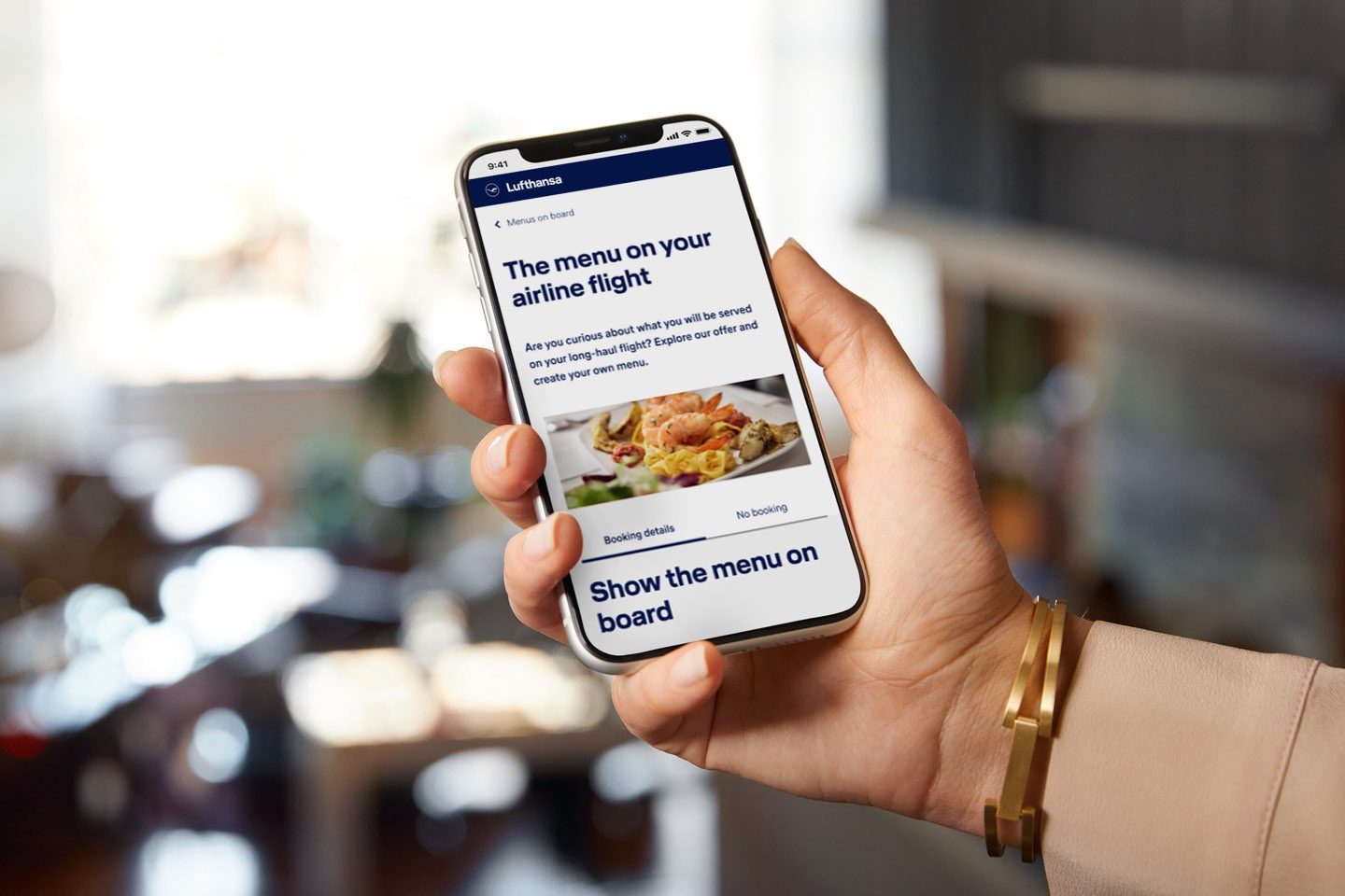 Hand holding a smartphone showing Lufthansa’s in-flight menu.