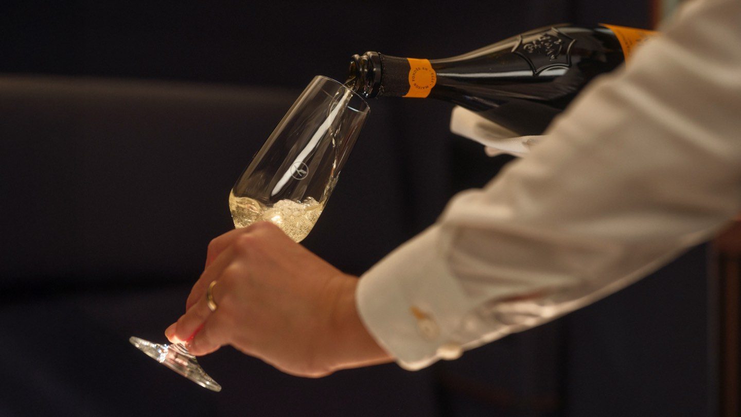 A person elegantly pours champagne into a glass, showcasing a moment of celebration and luxury.