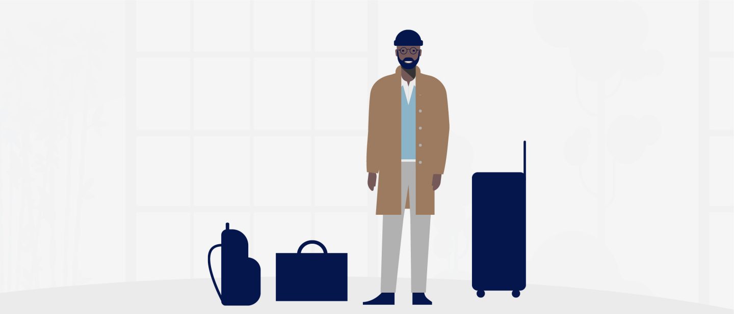 Man standing next to a suitcase and backpack.