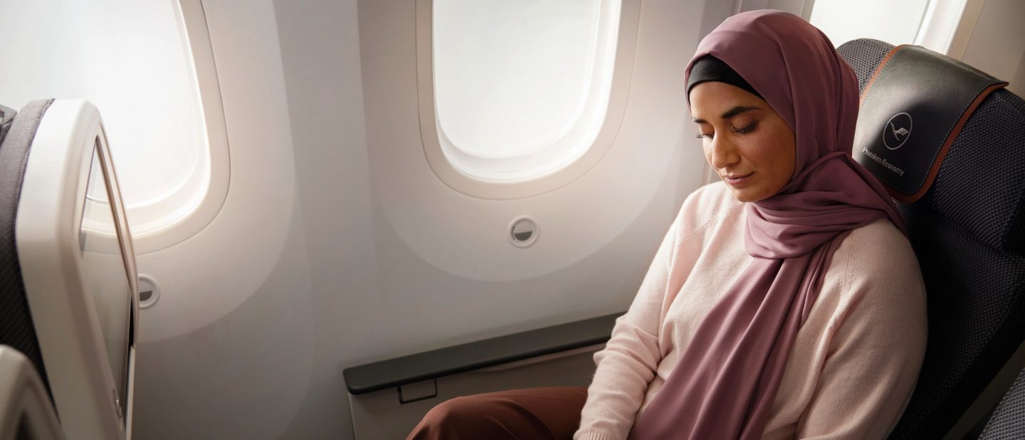 Woman sitting in a Classic Seat in Premium Economy Class