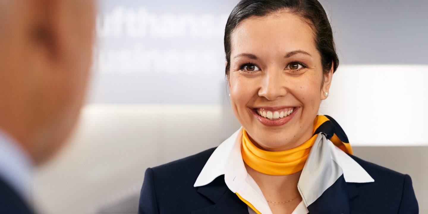 Welcome! A female member of service staff greets a passenger.