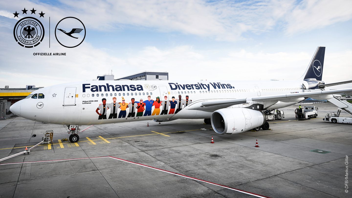 Airplane on the runway with the words Fanhansa Diversity Wins and illustrated figures on it.