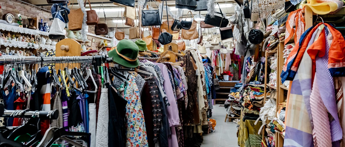 A busy vintage clothing store in Budapest with shelves full of various garments and accessories