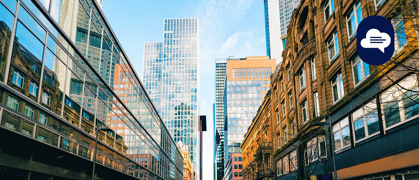Team Stories: View through a street canyon in Frankfurt to skyscrapers and blue sky.