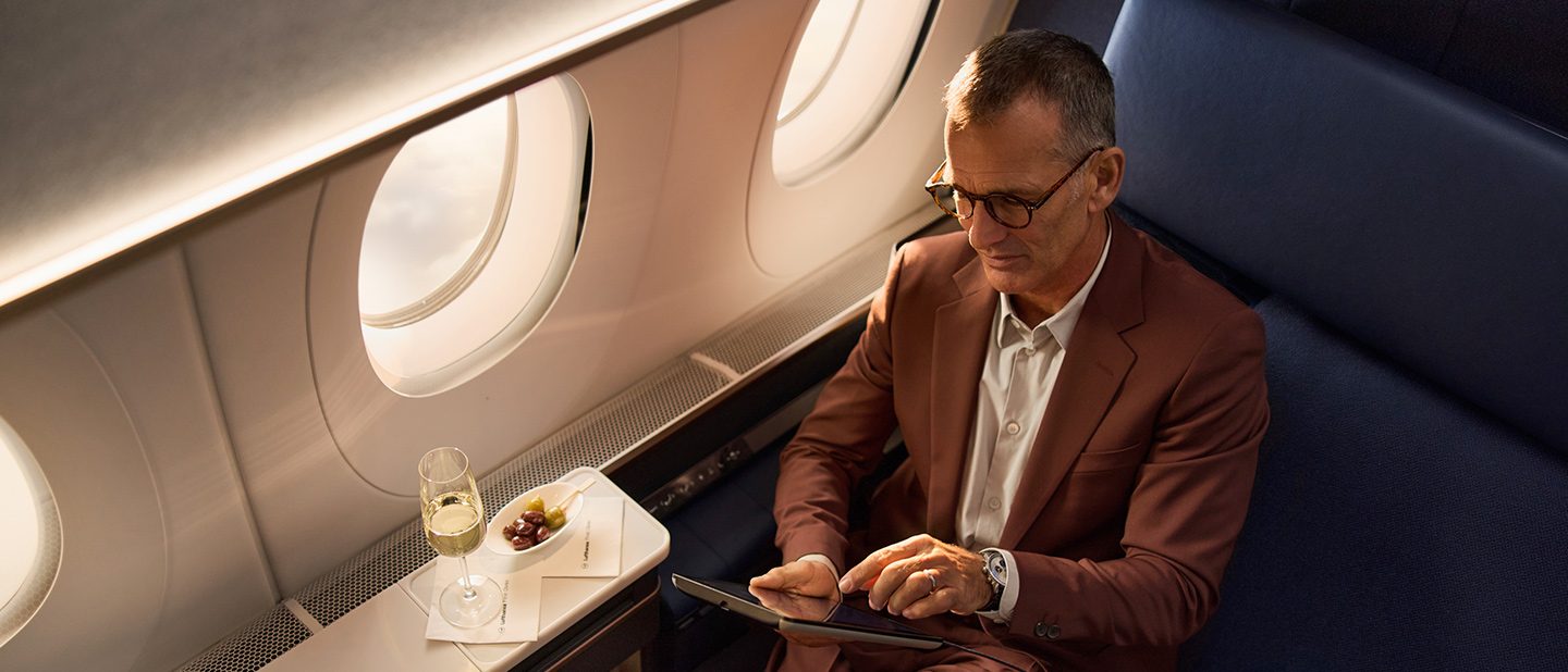 Man in a suit working on a tablet in the Lufthansa Allegris Suite. 
